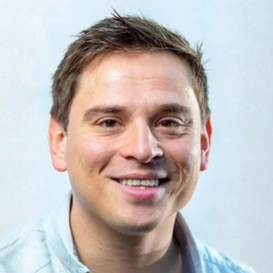 Close up portait of David Willumsen wearing a light blue shirt